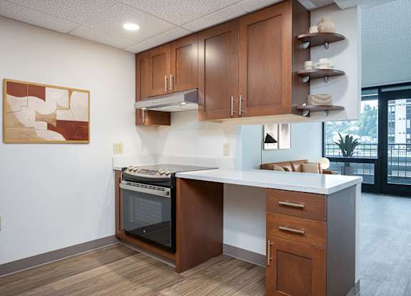 A kitchen with a white counter top and wooden cabinets.