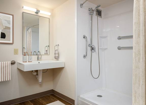 A white bathroom with a shower and sink.
