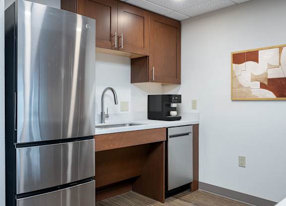 A modern kitchen with a stainless steel refrigerator and a microwave oven.