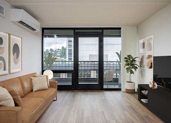 A living room with a brown couch and a black TV.