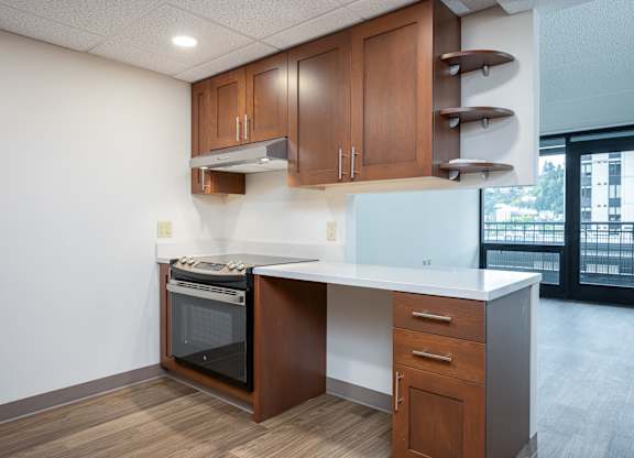 A kitchen with a white counter top and wooden cabinets.