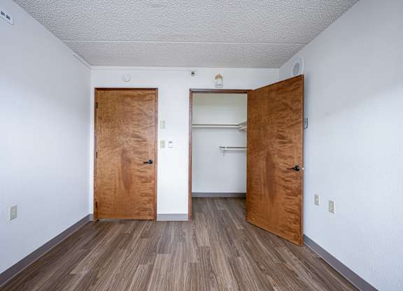 A room with two wooden doors and a white wall.