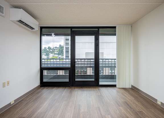 A room with a sliding door and a balcony outside.