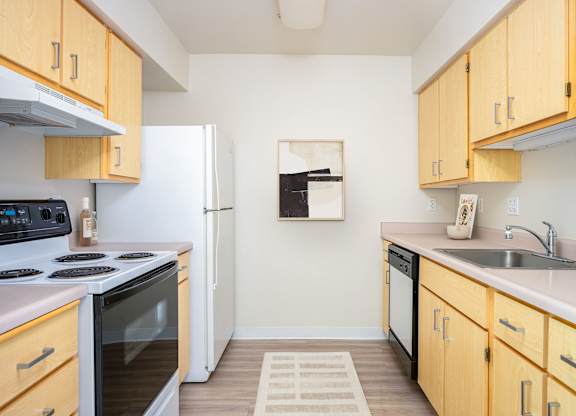 A kitchen with wooden cabinets and a white refrigerator.