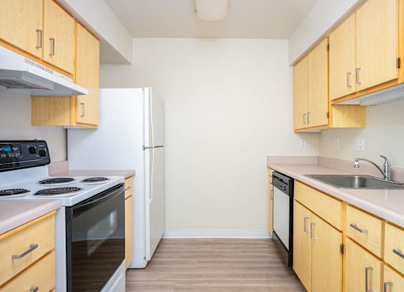 A kitchen with wooden cabinets and a white refrigerator.