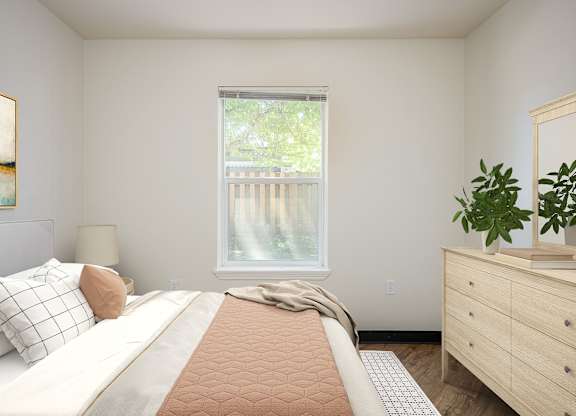 A bedroom with a large bed, a window with a view of a deck, and a wooden dresser.