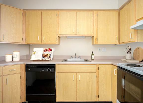 A kitchen with wooden cabinets and appliances.