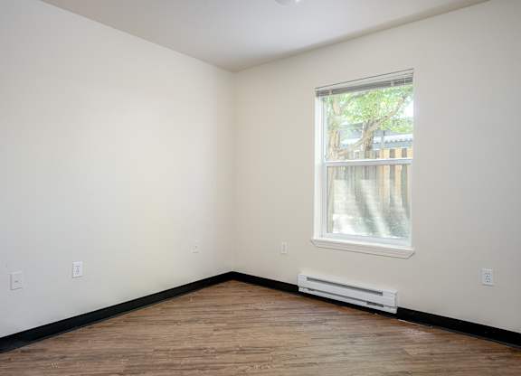 A room with a window and a radiator on the wall.