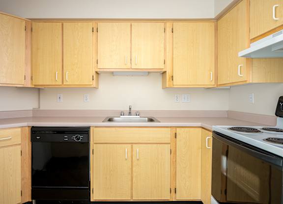 A kitchen with wooden cabinets and a black oven.
