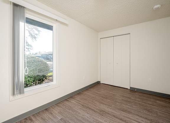 A room with a sliding glass door and a wooden floor.