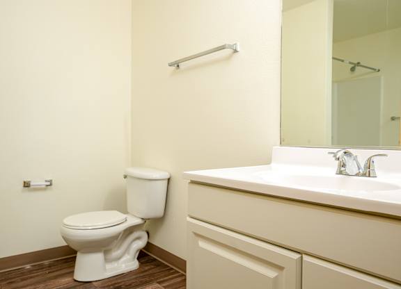 A white toilet sits next to a sink in a bathroom.