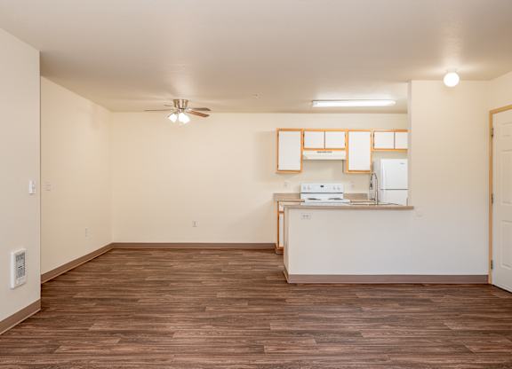 A room with wooden floors and a white ceiling with a fan.