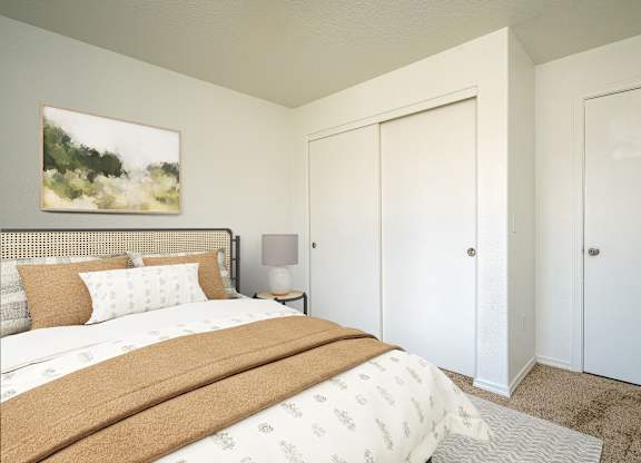 A bedroom with a large bed and a painting on the wall.