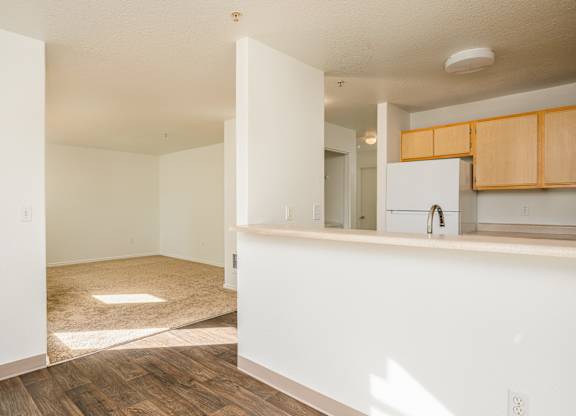 A kitchen area with wooden floors and white walls.
