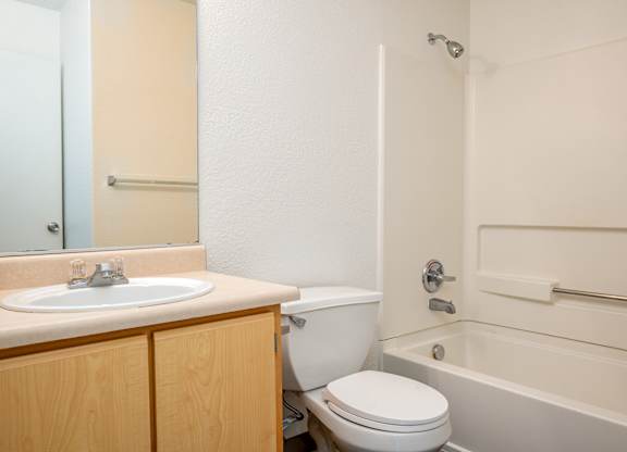 A bathroom with a toilet, sink, and bathtub.