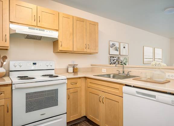 A kitchen with wooden cabinets and white appliances.
