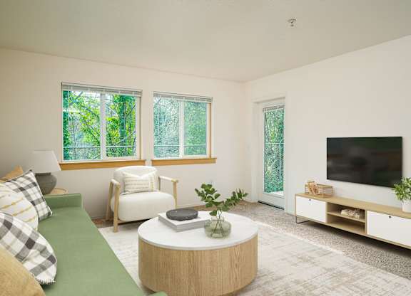A living room with a green couch, a white chair, a round table, and a television.