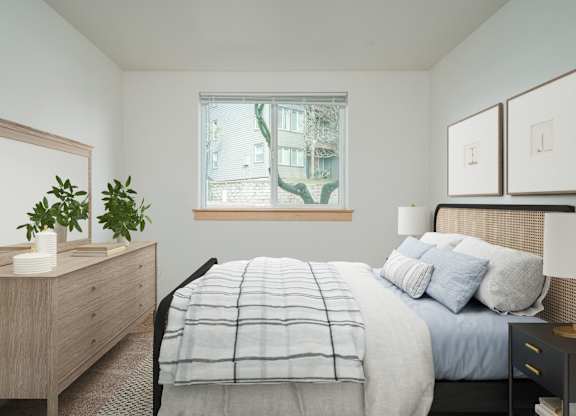 A bedroom with a bed, nightstand, and a window.