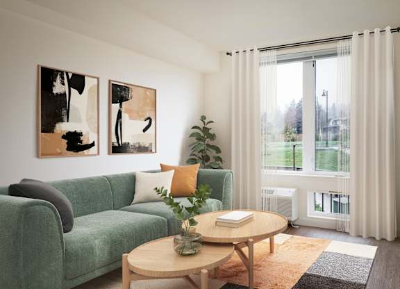 A living room with a green couch, a coffee table, and two abstract paintings on the wall.