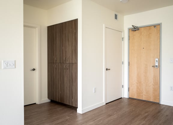 an empty room with a wooden door and a closet