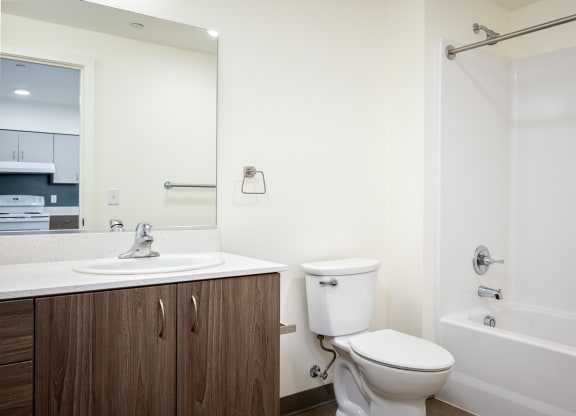 a bathroom with a toilet sink and shower and a mirror