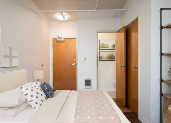 a bedroom with a bed and a closet and a door to a bathroom