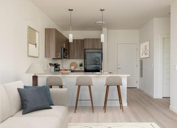 A modern kitchen with a white couch and wooden bar stools.