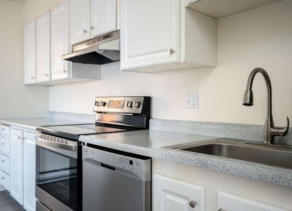 A modern kitchen with a stove, oven, and sink.