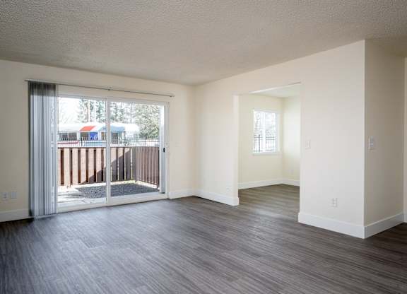 A room with a sliding glass door leading to a balcony.