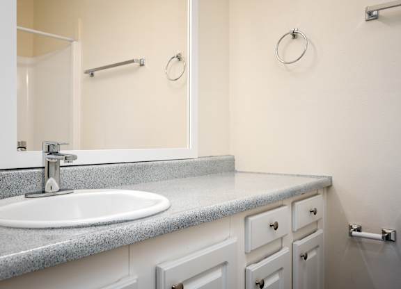 A bathroom with a sink, mirror, and toilet.