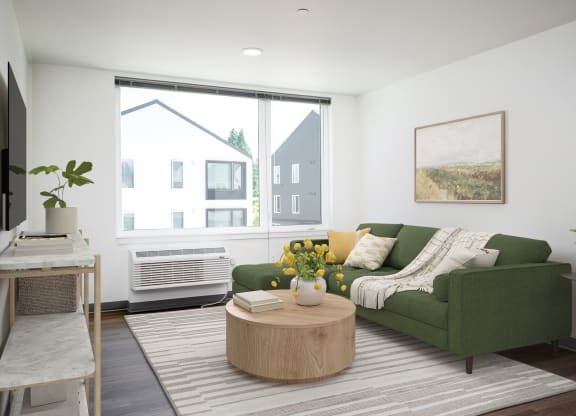 a living room with a green couch and a large window
