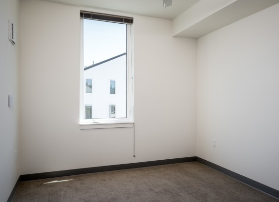 room with a large window and a carpet