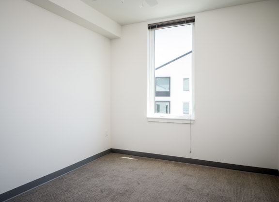 an empty room with a window and a carpet