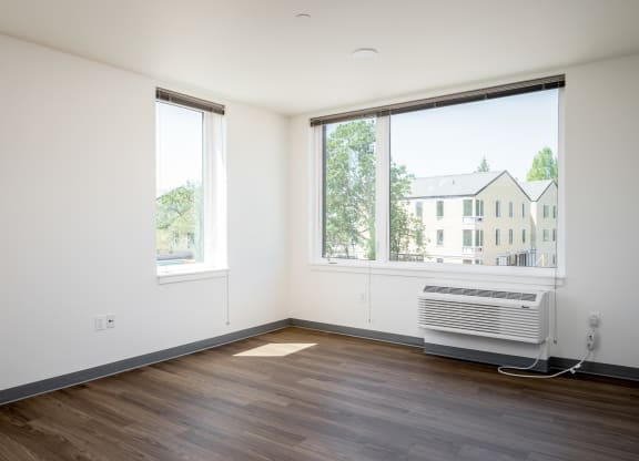 an empty room with a radiator and two windows