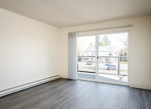 A room with a sliding glass door leading to a parking lot.