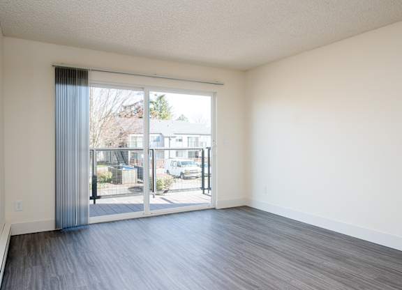 A room with a sliding glass door leading to a balcony.