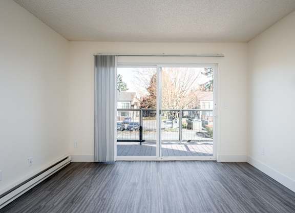 A room with a sliding glass door leading to a parking lot.