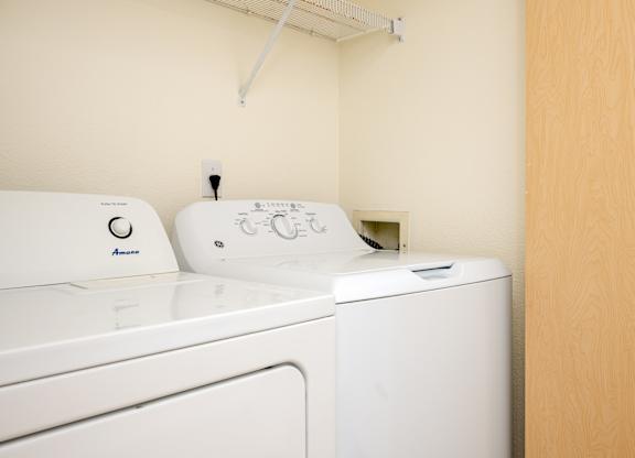 A white washing machine and dryer in a small room.