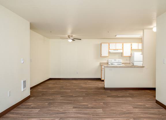 A room with wooden flooring and a ceiling fan.