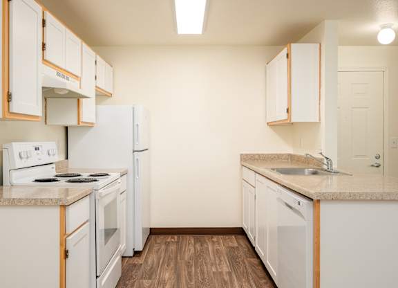A kitchen with white appliances and wooden cabinets.