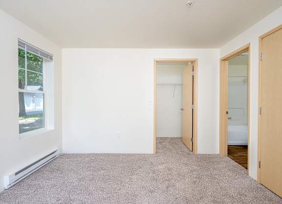 A room with a carpeted floor and a window.