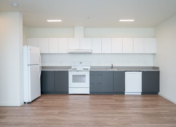 a kitchen with white appliances and gray cabinets