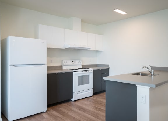 a kitchen with white appliances and gray countertops