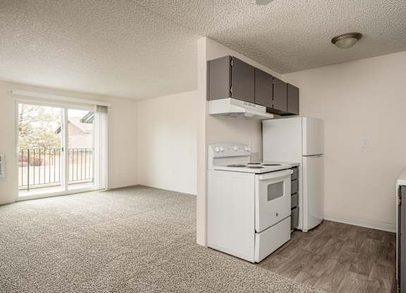 A kitchen with white appliances and a window.