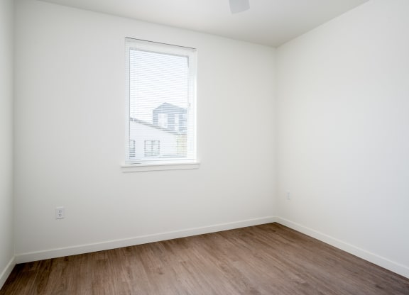 an empty room with white walls and a window