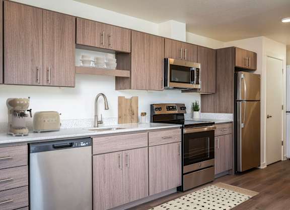 A modern kitchen with wooden cabinets and stainless steel appliances.