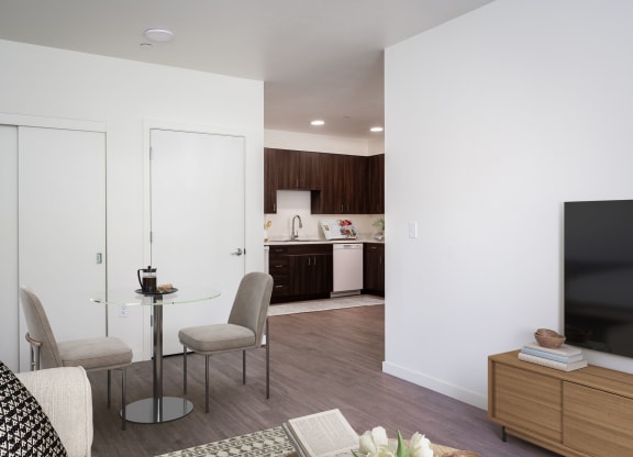 a living room and kitchen with a table and chairs