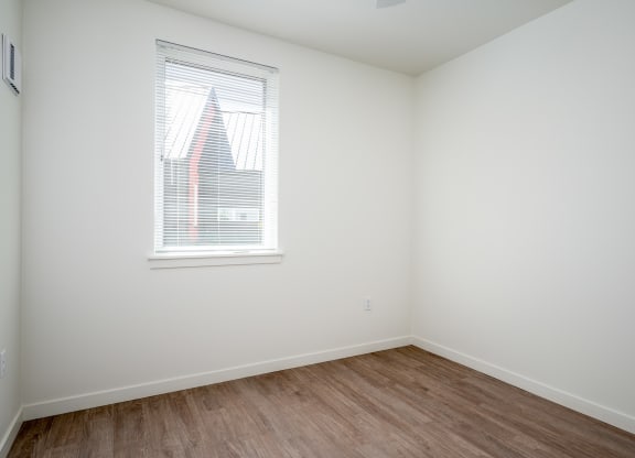 an empty room with white walls and a window