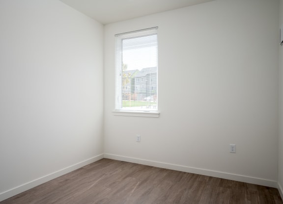 an empty room with white walls and a window