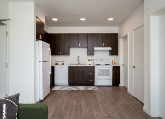 a kitchen with white appliances and dark wood cabinets